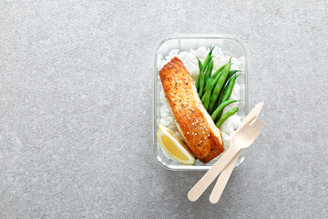 Lunch box containers with grilled salmon fish fillet, rice and green beans