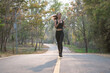© Songsak C - Young woman running outdoors in green park at lovely sunny summer day.