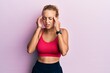 © Krakenimages.com - Beautiful caucasian woman wearing sportswear with hand on head for pain in head because stress. suffering migraine.