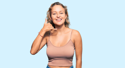 Wall Mural - Beautiful caucasian woman wearing casual clothes smiling doing phone gesture with hand and fingers like talking on the telephone. communicating concepts.