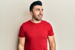 © Krakenimages.com - Young hispanic man wearing casual clothes looking to side, relax profile pose with natural face and confident smile.