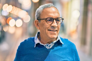 Wall Mural - senior grey-haired man smiling happy standing at the city.