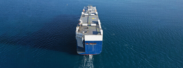 Aerial drone ultra wide photo of huge car carrier ship RO-RO (Roll on Roll off) cruising in Mediterranean deep blue Aegean sea