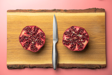 Wall Mural - ripe pomegranate on a pink background. love. Fruit