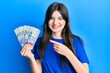 © Krakenimages.com - Young beautiful caucasian girl holding south african 100 rand banknotes smiling happy pointing with hand and finger