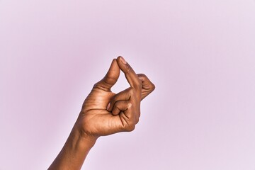 Arm and hand of black middle age woman over pink isolated background snapping fingers for success, easy and click symbol gesture with hand