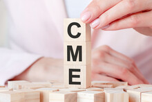 The Word CME On A Wooden Toy Blocks With Womans Hands