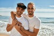 © Krakenimages.com - Young gay couple smiling happy hugging at the beach.