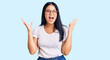 © Krakenimages.com - Young beautiful asian girl wearing casual clothes and glasses celebrating crazy and amazed for success with arms raised and open eyes screaming excited. winner concept