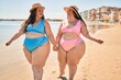 © Krakenimages.com - Two plus size overweight sisters twins women happy and proud of their bodies walking at the beach on summer holidays