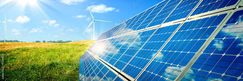 Solar Panels And Wind Turbines In Grassy Field With Sunlight ...