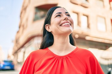 Wall Mural - Young latin girl smiling happy walking at the city.