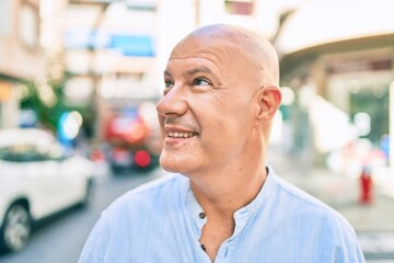 Wall Mural - Middle age bald man smiling happy walking at the city.