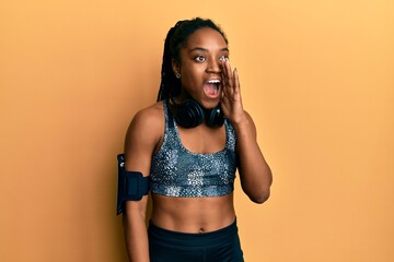 Sticker - African american woman with braided hair wearing sportswear and arm band shouting and screaming loud to side with hand on mouth. communication concept.