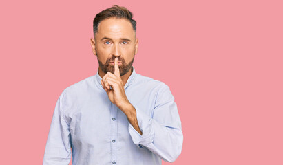 Sticker - Handsome middle age man wearing business shirt asking to be quiet with finger on lips. silence and secret concept.