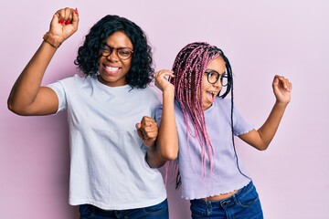 Poster - Beautiful african american mother and daughter wearing casual clothes and glasses dancing happy and cheerful, smiling moving casual and confident listening to music