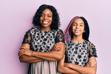 Poster - Beautiful african american mother and daughter wearing sexy party dress happy face smiling with crossed arms looking at the camera. positive person.