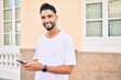 © Krakenimages.com - Young arab man smiling happy using smartphone at the city.