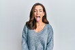 © Krakenimages.com - Young brunette woman wearing casual winter sweater sticking tongue out happy with funny expression. emotion concept.