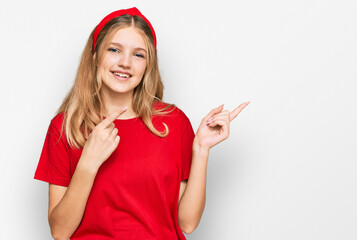 Beautiful young caucasian girl wearing casual red t shirt smiling and looking at the camera pointing with two hands and fingers to the side.