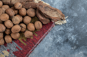 Some of healthy walnuts with tree bark on a gray background