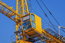 Bottom View Of The Construction Crane Cab With The Operator On The Background Of The Winter Blue Sky