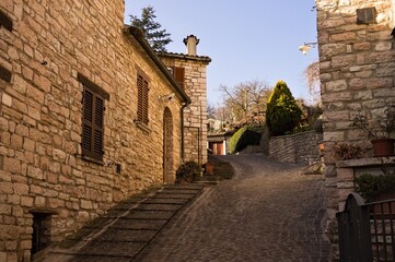 Wall Mural - A staircase in a medieval Italian village with brick houses and floral decorations (Pesaro, Italy, Europe)