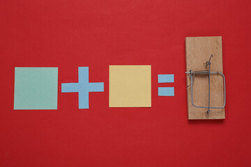 Equation with blank pieces of paper and a mousetrap on a red background. Cheating concept, trap