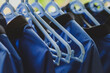 Stylish blue clothes hangers and beautiful blue shirts hang together.