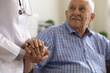 © fizkes - Close up supportive female caregiver wearing white uniform holding mature man hand, giving psychological help, expressing empathy and care, doctor comforting sick senior patient grandfather