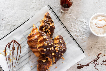 Wall Mural - Chef making dark chocolate croissants with nut and flower of salt on top. Tasty and freshly croissants with copy space. 