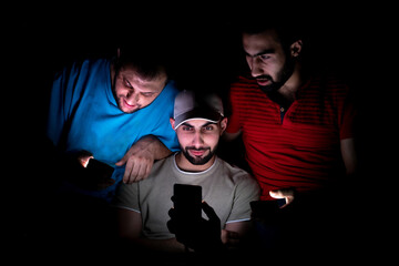 portrait of middle eastern guys setting together in a dark room