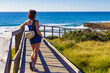 © anetlanda - Woman walking on wooden path on sea shore