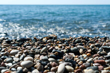 Beach Stones And Pebbles In Front Of Glittering Sea