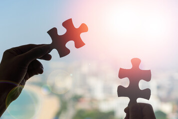 Autism and autistic ,child putting puzzle together. Hands of children students holding pieces of jigsaw as a symbol for  teamwork in school.