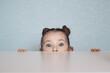 © Andy Shell - Portrait of little girl looking from under the table. High quality photo
