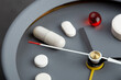 Take medicine on time! Creative healthcare and medicine concept - clock with drugs and pills. Cold and flu season. Period of diseases.