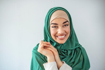 Portrait of cute smile Muslim teenage girl wearing islamic dress hijab is looking to camera. Woman in traditional Muslim clothing, smiling. 