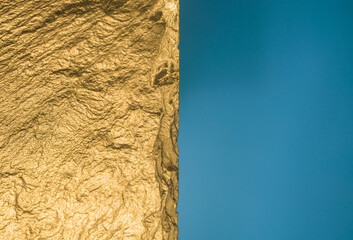 Gold texture. Rough structure mineral. Rock texture. Gold Ore. Gold rocks. Stone blue background.