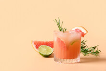 Grapefruit Soda With Lime Garnish Rosemary Sprig On Color Beige Background. Mocktail Paloma. Close Up.