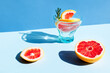 © Caterina Trimarchi - Summer cocktail with grapefruit and rosemary and juicy slices citrus fruits. Fresh healthy grapefruit beverage on sunlight with hard shadows. Minimal food creative concept on blue pastel background.