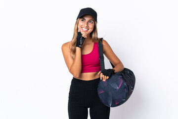 Wall Mural - Young sport woman with sport bag over isolated white background thinking an idea while looking up