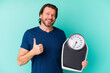 © Asier - Middle age dutch man holding a scale isolated on blue background smiling and raising thumb up