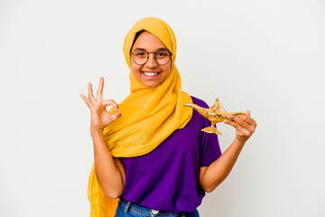 Young muslim woman holding a lamp isolated on white background cheerful and confident showing ok gesture.