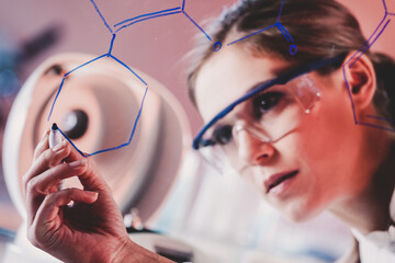 Fototapete - Portrait of a confident female health care professional in his working environment writing structural chemical formula on a glass board.