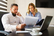 © Miljan Živković - Young caucasian man and woman at office looking project documents analyzing reports or contracts - male and female colleague at work thinking about ongoing project - business and management concept