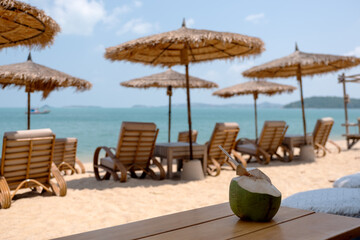 Wall Mural - A fresh coconut on wooden table at tropical beach cafe