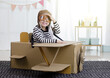 © DN6 - Asian little child girl playing with cardboard toy airplane handicraft isolated in home with copy space for your text, Creative with family and dreaming of flying concept