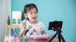 © DN6 - Happy little Asian girl beauty blogger recording video for teaching to use cosmetic make up.