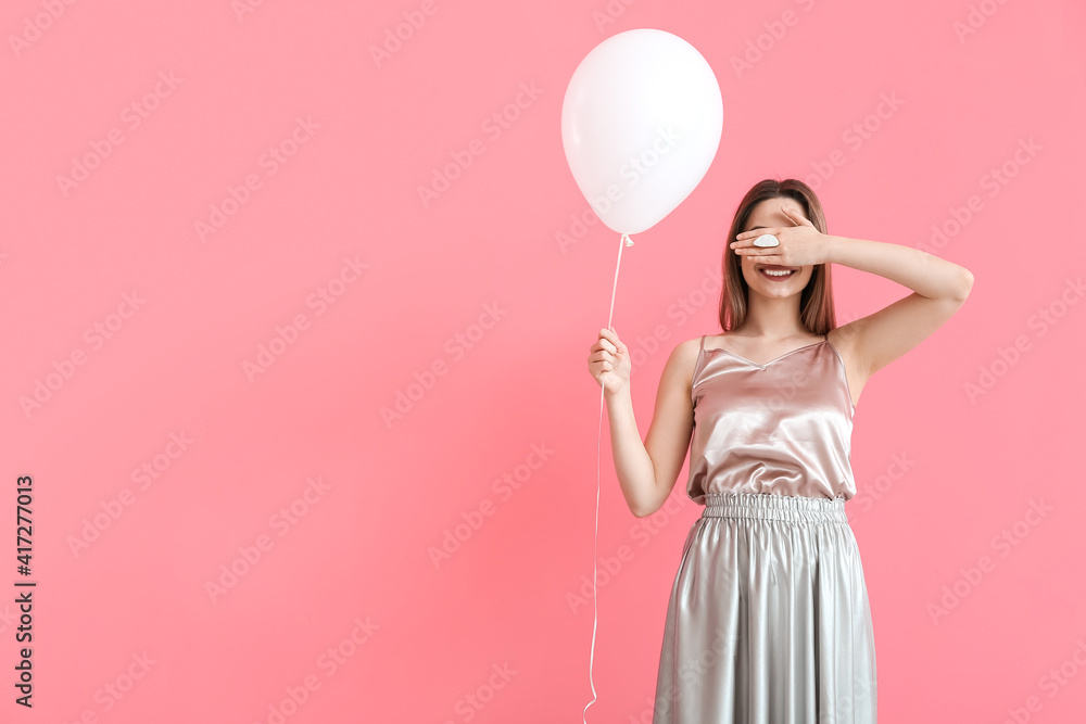 Beautiful young woman with balloon on color background